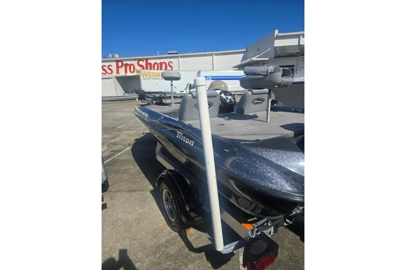 Slide: The Image of 2006 Triton Tr-176 boat parked outside a store, featuring sleek design and seating. - 9