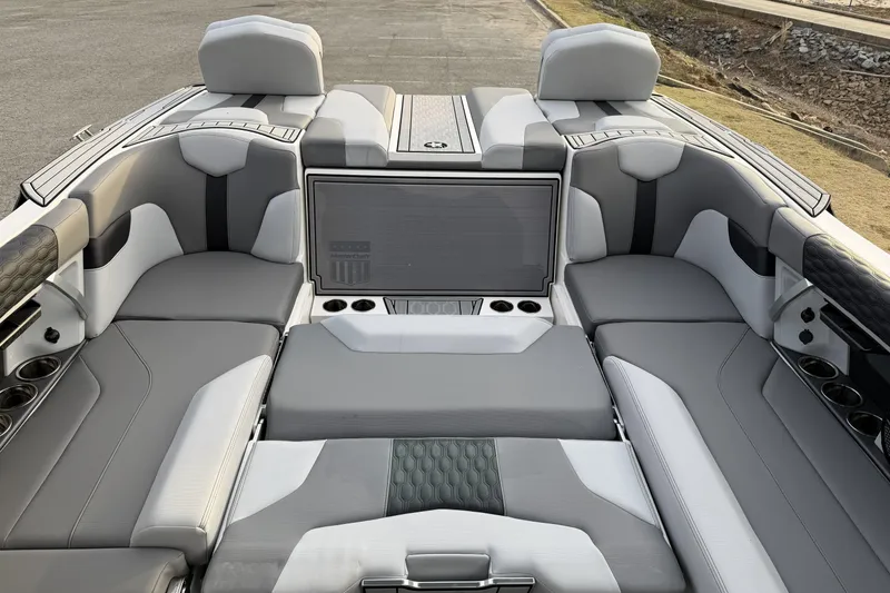 Slide: The Image of 2023 MasterCraft XT24 boat interior with luxurious gray seating and cup holders. - 12