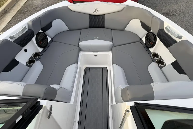 Slide: The Image of 2023 MasterCraft XT24 boat interior with gray seating and cup holders. - 14