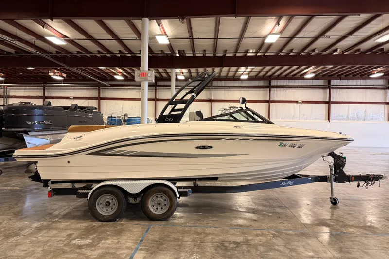 The Image of 2018 Sea Ray SPX 210 boat on trailer in indoor storage facility. - 1