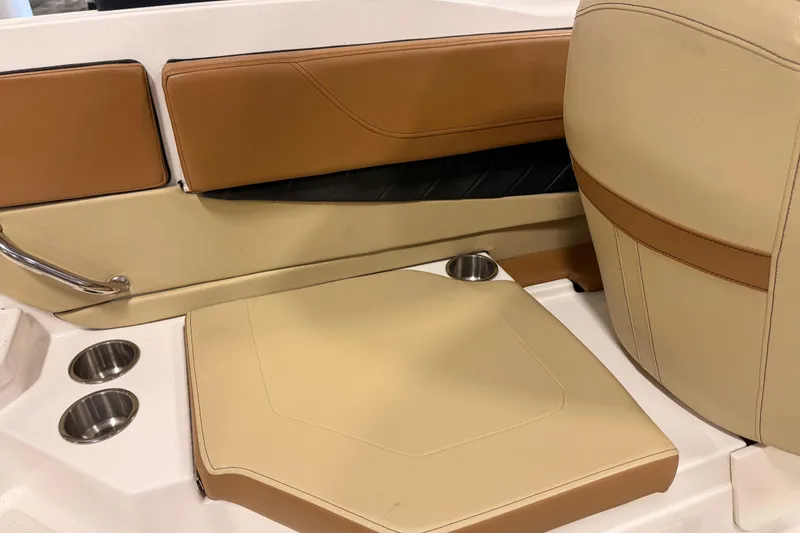 Slide: The Image of 2018 Sea Ray SPX 210 boat interior with tan and brown seating, cup holders, and stainless steel accents. - 13