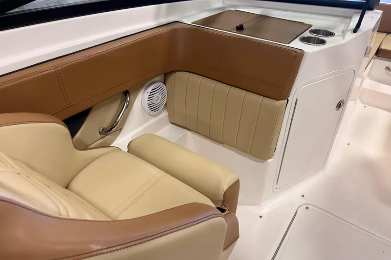Slide: The Image of 2018 Sea Ray SPX 210 boat interior with tan and brown seating, cup holders, and storage. - 18