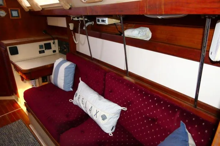 Slide: The Image of Interior of a 1989 Catalina 34 sailboat with red cushioned seating and nautical decor. - 12