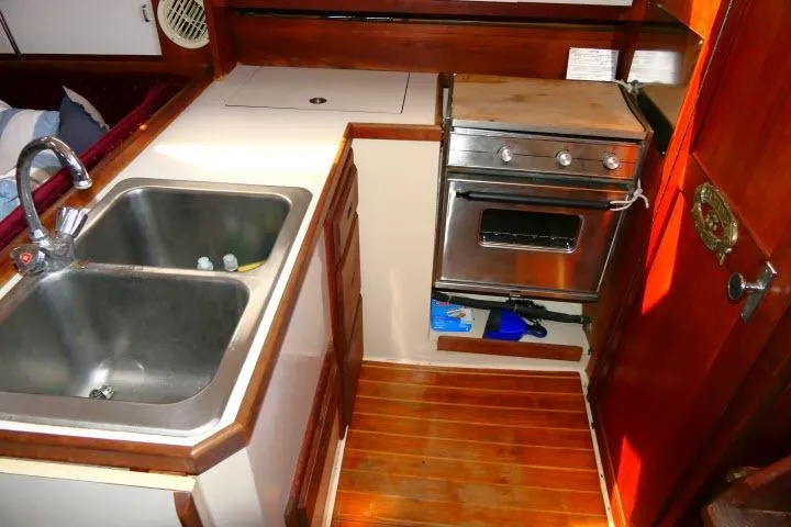 Slide: The Image of 1989 Catalina 34 yacht kitchen with stainless steel sink and compact oven. - 15
