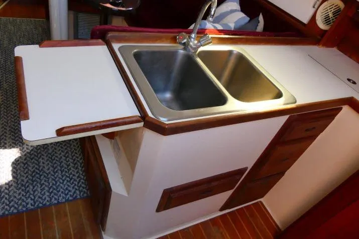 Slide: The Image of 1989 Catalina 34 yacht kitchen with double sink and wooden cabinetry. - 16