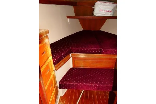Slide: The Image of 1989 Catalina 34 interior cabin with burgundy cushions and wooden cabinetry. - 20