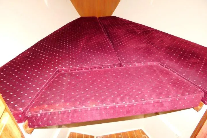 Slide: The Image of V-berth with maroon cushions in a 1989 Catalina 34 sailboat interior. - 22