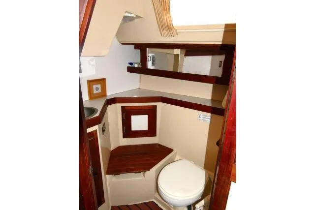 Slide: The Image of 1989 Catalina 34 yacht bathroom with wooden accents and compact design. - 25