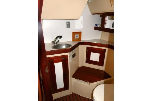 Slide: The Image of 1989 Catalina 34 yacht bathroom with sink, wooden cabinetry, and compact design. - 26