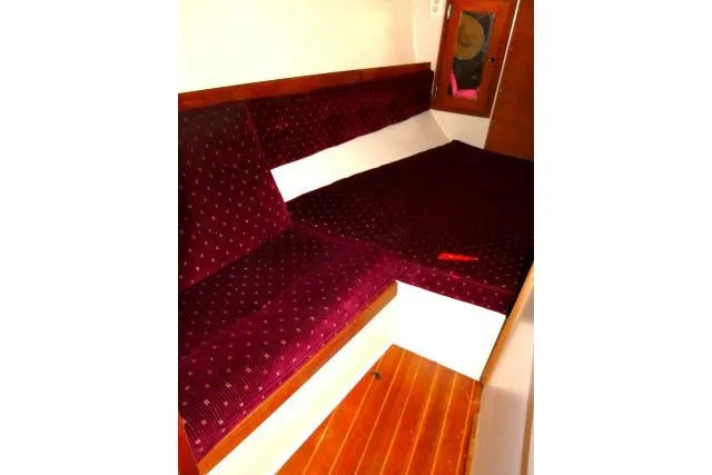 Slide: The Image of 1989 Catalina 34 interior with red upholstered seating and wooden flooring. - 27