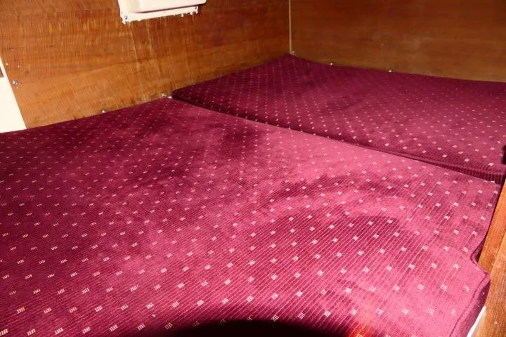 Slide: The Image of Interior cabin of a 1989 Catalina 34 sailboat with maroon cushions. - 28