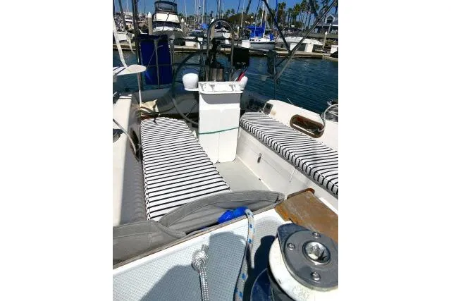 Slide: The Image of 1989 Catalina 34 sailboat cockpit with striped cushions, docked in a marina. - 32