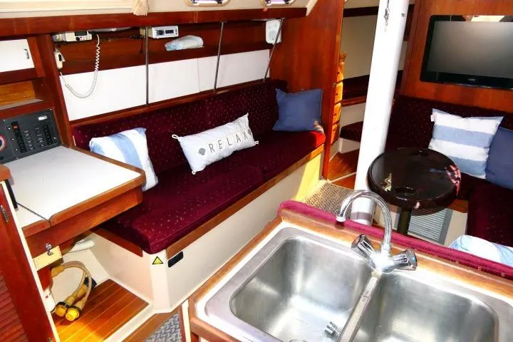 Slide: The Image of Interior of 1989 Catalina 34 sailboat with cozy seating and kitchen area. - 4