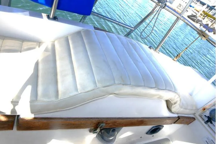 Slide: The Image of White cushioned seating on a 1989 Catalina 34 sailboat, with a view of the water. - 47