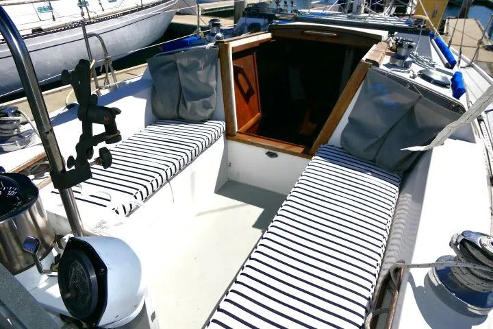Slide: The Image of 1989 Catalina 34 sailboat cockpit with striped cushions and wooden hatch. - 48