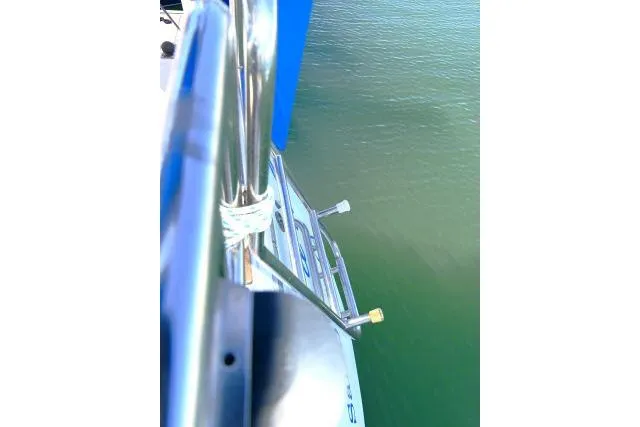 Slide: The Image of 1989 Catalina 34 sailboat railing and ladder over calm water. - 52