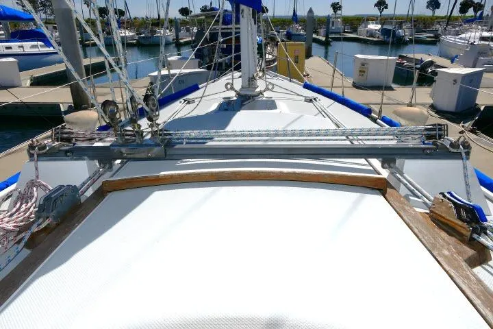 Slide: The Image of 1989 Catalina 34 sailboat deck view in marina, showcasing rigging and docked boats. - 53