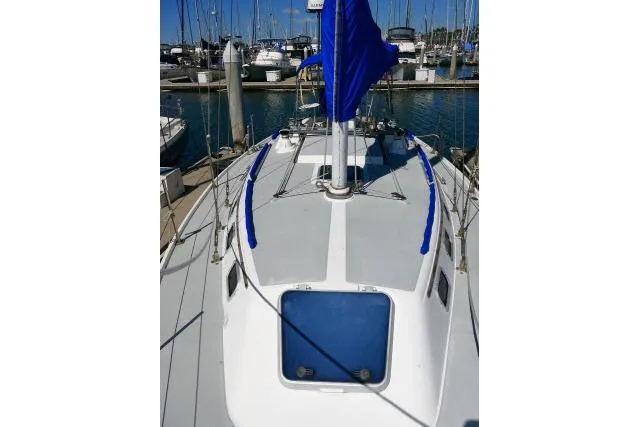 Slide: The Image of 1989 Catalina 34 sailboat deck view at marina, featuring blue sail cover. - 58