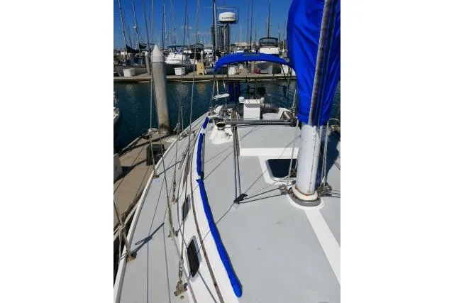 Slide: The Image of 1989 Catalina 34 sailboat docked at marina with blue accents and clear sky. - 59