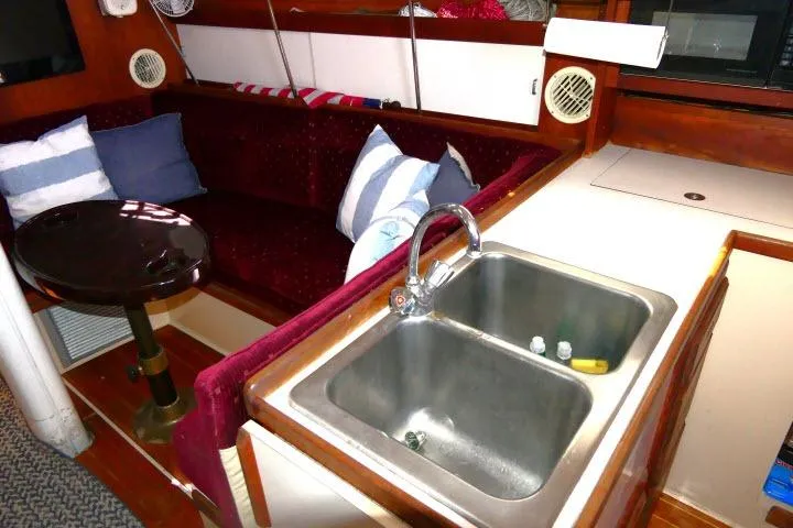 Slide: The Image of Interior of 1989 Catalina 34 sailboat with sink, seating, and cushions. - 6