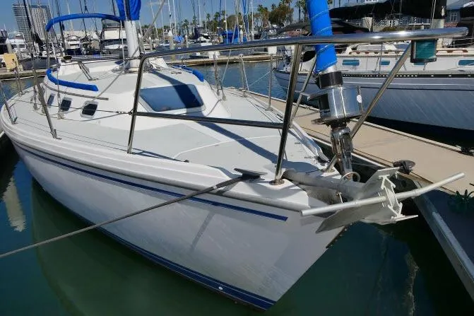 Slide: The Image of 1989 Catalina 34 sailboat docked in marina, featuring sleek design and blue accents. - 60