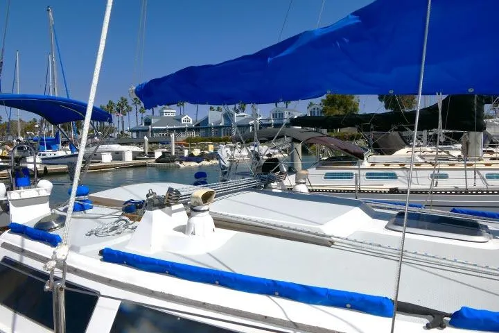 Slide: The Image of 1989 Catalina 34 sailboat docked in a sunny marina with blue covers. - 65