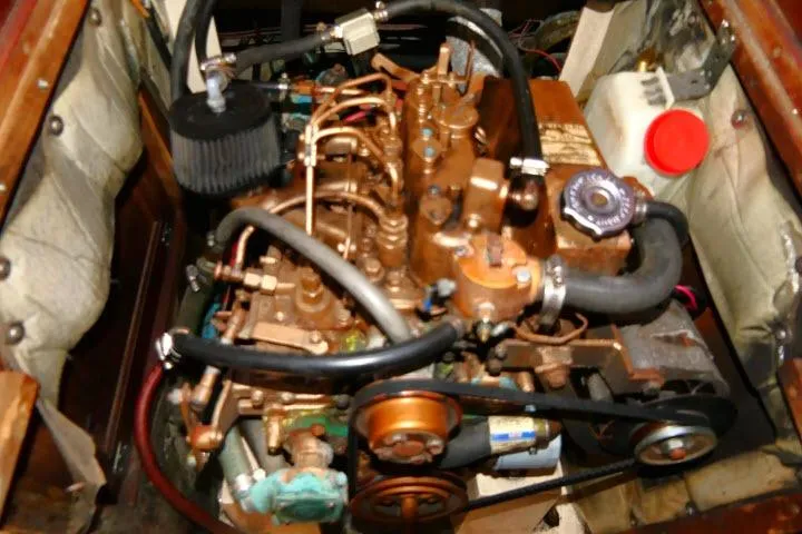Slide: The Image of Engine compartment of a 1989 Catalina 34 sailboat, showcasing mechanical components and hoses. - 68