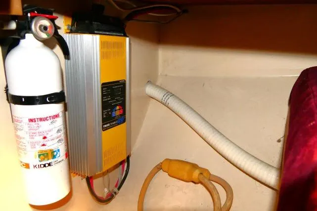 Slide: The Image of Fire extinguisher and battery charger in 1989 Catalina 34 boat interior. - 71
