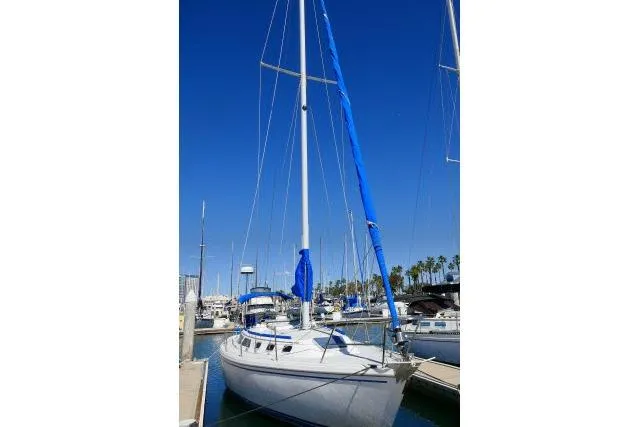 Slide: The Image of 1989 Catalina 34 sailboat docked in marina under clear blue sky. - 76