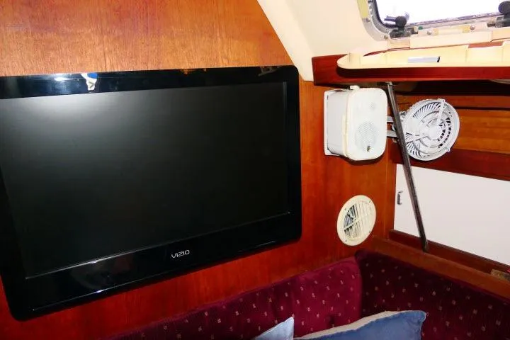 Slide: The Image of Interior of 1989 Catalina 34 sailboat with TV, fan, and speaker setup. - 9