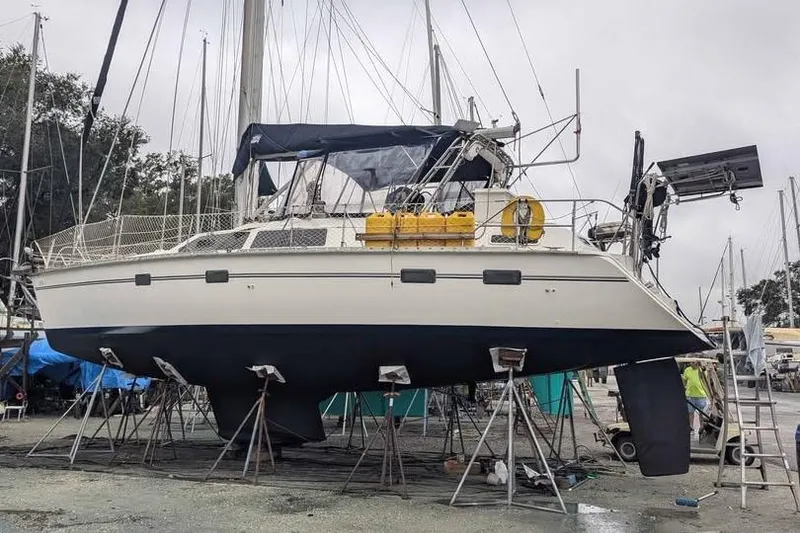 The Image of 1992 Hunter Passage 42 sailboat on stands in a marina, undergoing maintenance. - 1