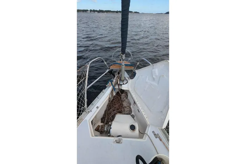 Slide: The Image of Bow of 1992 Hunter Passage 42 sailboat with open anchor locker on calm water. - 10