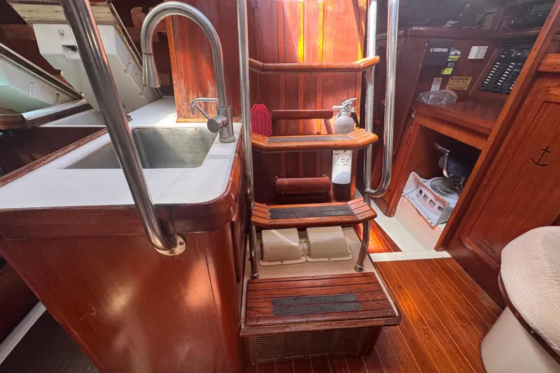 Slide: The Image of Interior of 1992 Hunter Passage 42 sailboat with wooden stairs and compact kitchen area. - 100
