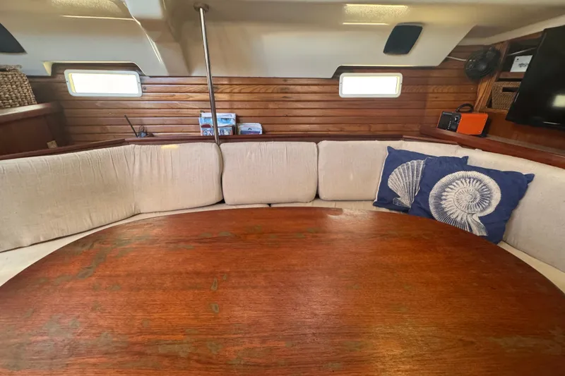 Slide: The Image of Interior of 1992 Hunter Passage 42 yacht with wooden table and cushioned seating. - 101