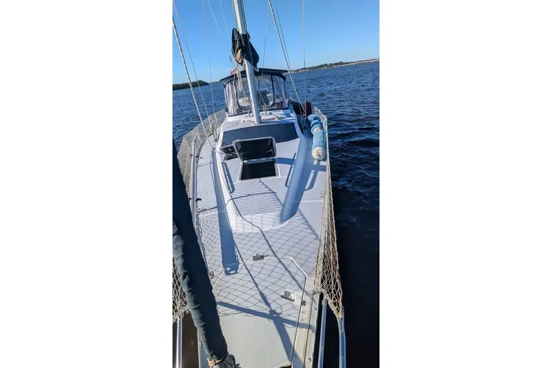 Slide: The Image of 1992 Hunter Passage 42 sailboat on calm water, showcasing deck and rigging. - 11