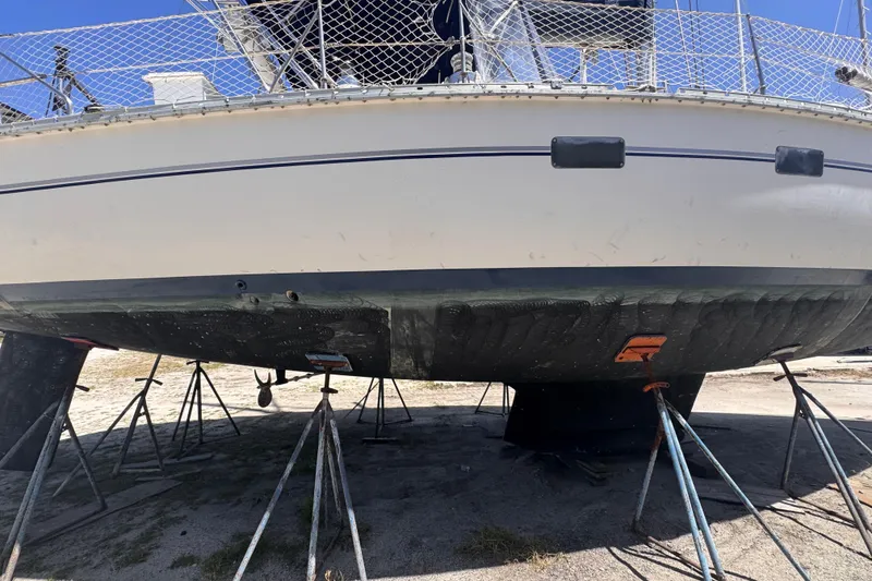 Slide: The Image of 1992 Hunter Passage 42 sailboat on stands, hull view, under maintenance. - 12