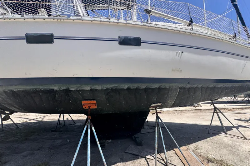 Slide: The Image of Hunter Passage 42 sailboat from 1992 on stands, showing hull and deck details. - 13