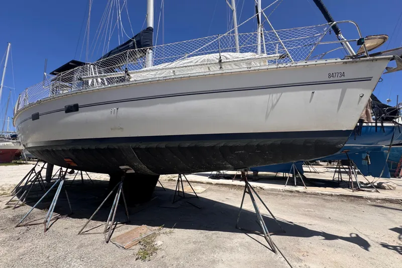 Slide: The Image of 1992 Hunter Passage 42 sailboat on stands in a boatyard under clear blue sky. - 14