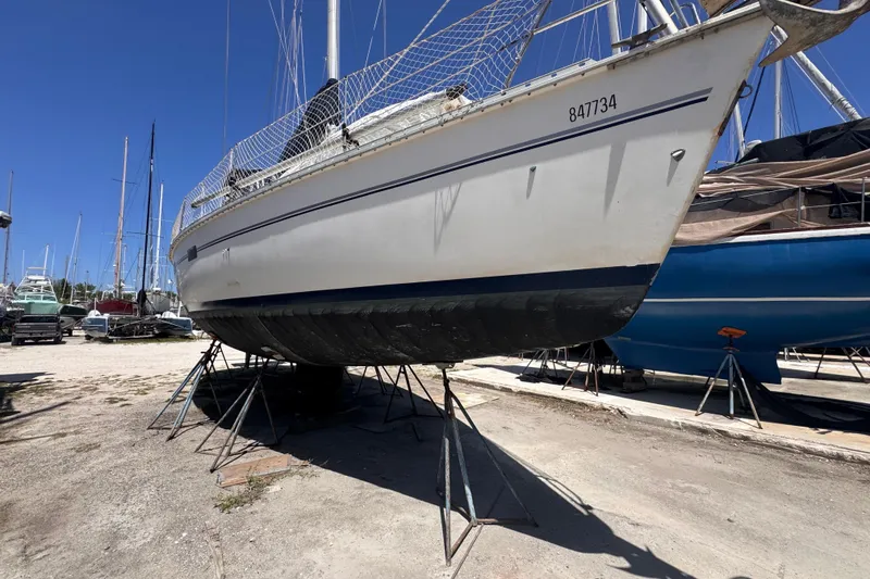 Slide: The Image of 1992 Hunter Passage 42 sailboat on stands in a boatyard under clear blue sky. - 15