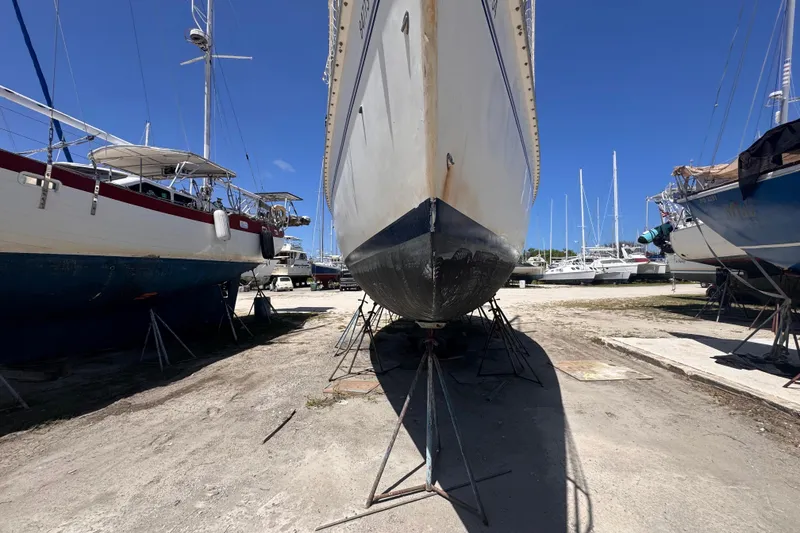 Slide: The Image of Sailboat Hunter Passage 42 (1992) on dry dock, surrounded by other boats under clear blue sky. - 16