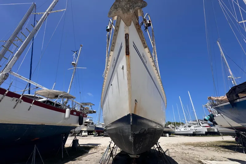 Slide: The Image of Hunter Passage 42 sailboat from 1992 on dry dock, surrounded by other boats. - 17