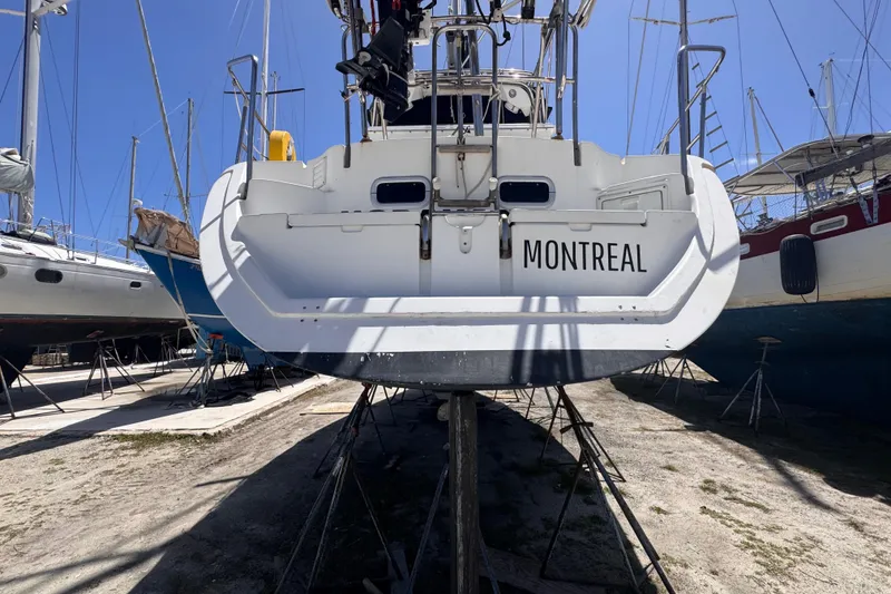 Slide: The Image of 1992 Hunter Passage 42 sailboat named Montreal on dry dock under clear blue sky. - 21