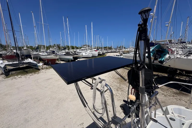Slide: The Image of Hunter Passage 42 sailboat with solar panel in a marina, surrounded by other boats. - 24
