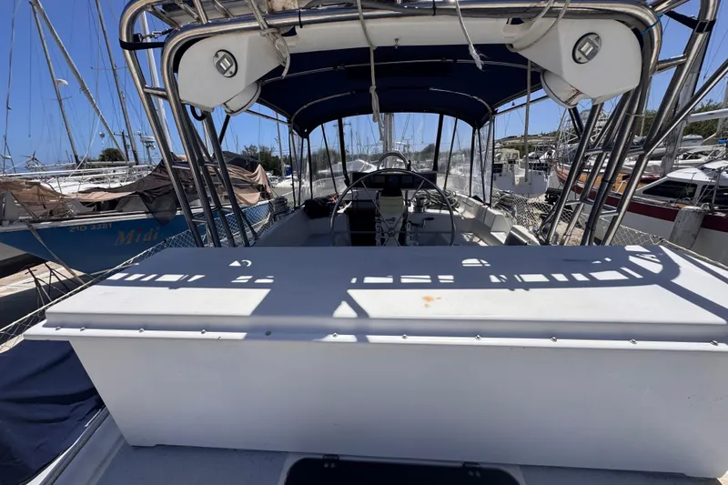Slide: The Image of 1992 Hunter Passage 42 sailboat cockpit with canopy, docked in a marina under clear skies. - 27