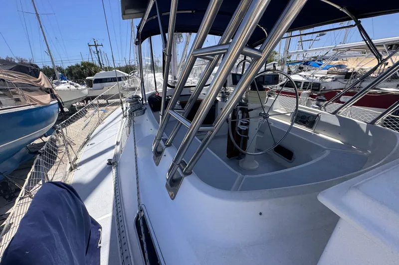 Slide: The Image of 1992 Hunter Passage 42 sailboat cockpit with steering wheel, docked among other boats. - 29