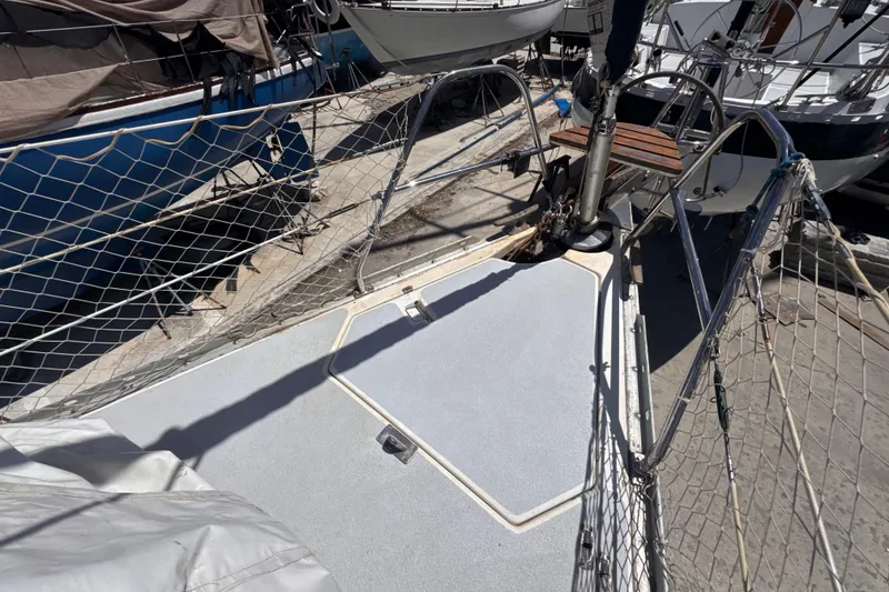 Slide: The Image of Deck of 1992 Hunter Passage 42 sailboat with safety netting and docked surroundings. - 48