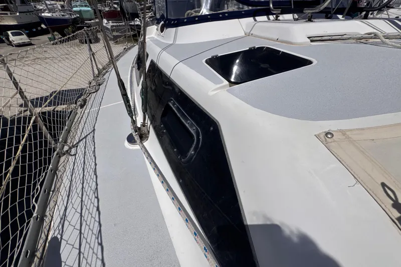 Slide: The Image of 1992 Hunter Passage 42 sailboat deck with netting and hatch, docked in a marina. - 50