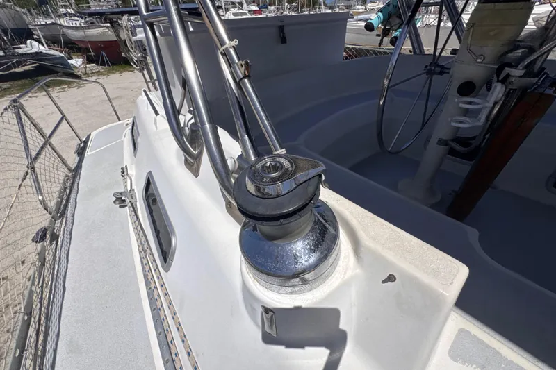 Slide: The Image of 1992 Hunter Passage 42 sailboat deck with winch and steering wheel in marina. - 53