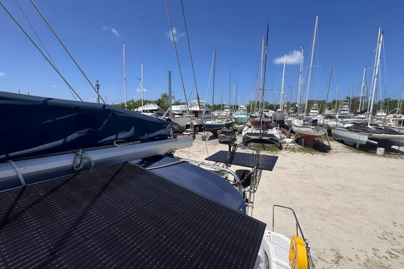 Slide: The Image of Sailboats in a marina, featuring a 1992 Hunter Passage 42 with solar panels. - 69