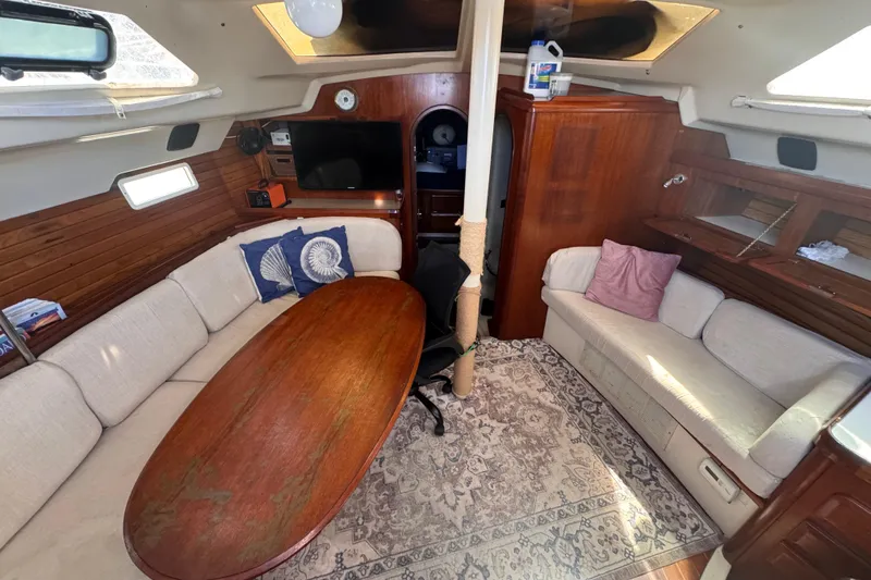 Slide: The Image of Interior of 1992 Hunter Passage 42 sailboat with cozy seating and wooden table. - 70